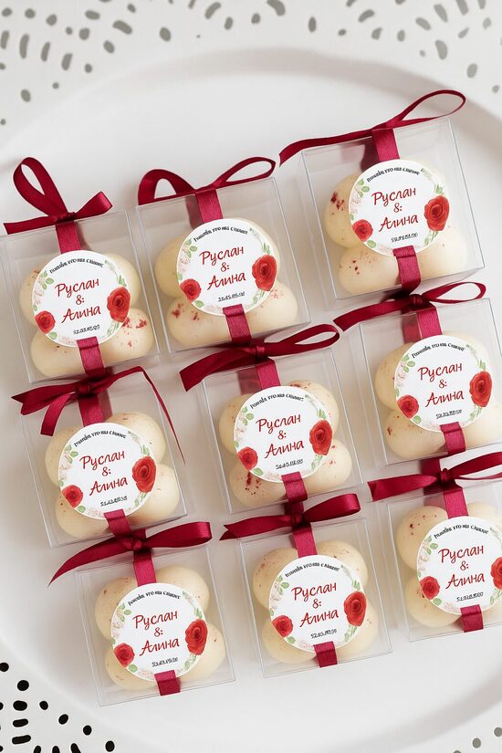 Personalizēta kāzu svece viesiem ar sarkanu lentīti un ziedu dizaina uzlīmi